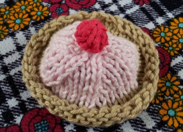 Sew cherry to top of cake